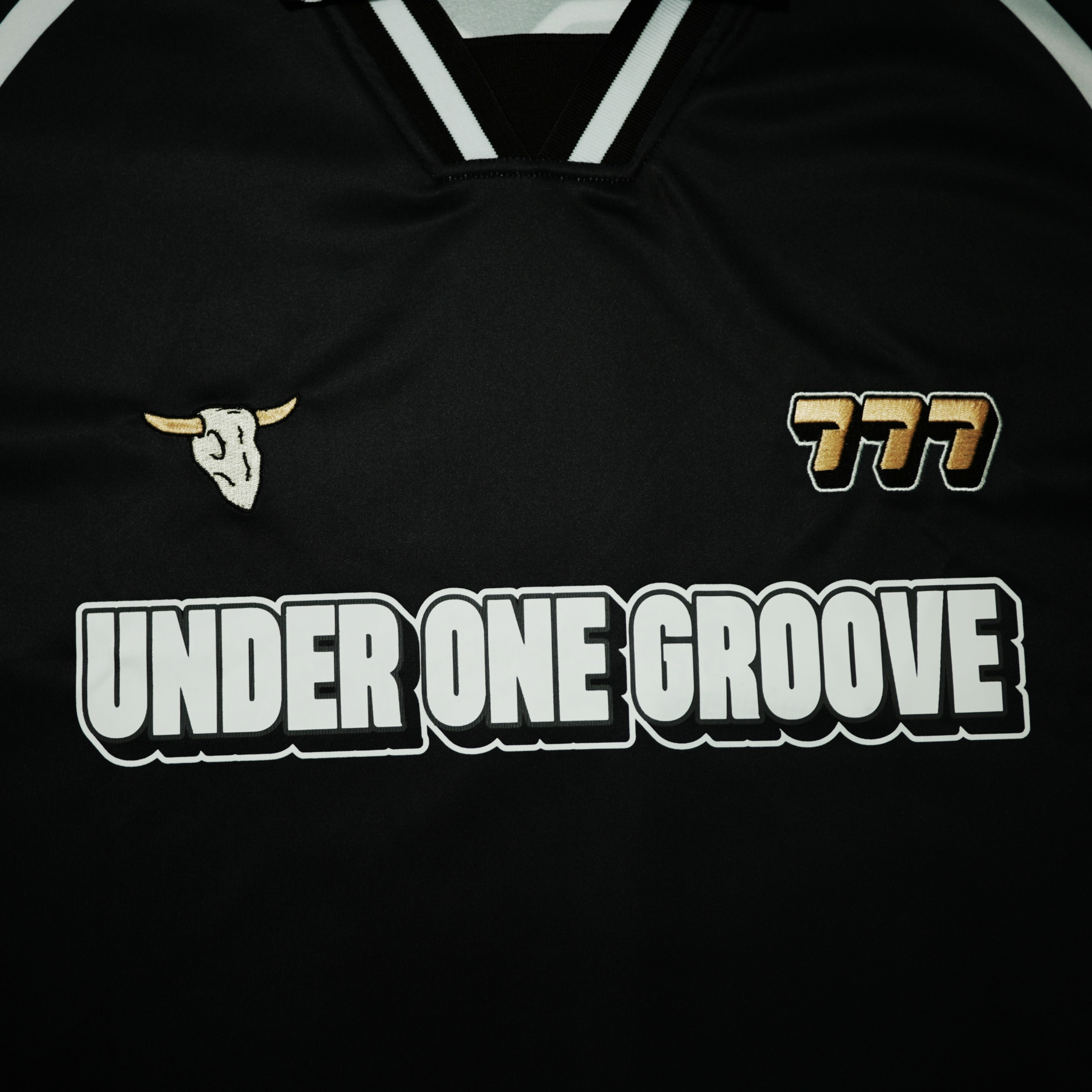Black sports jersey with 'Under One Groove' text and logo on a black background